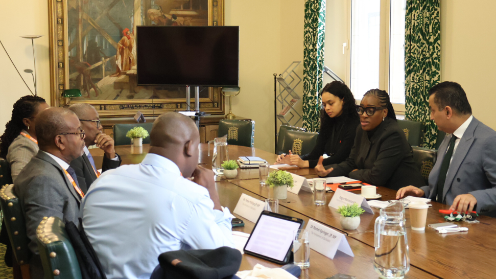 A group of people sat around a table in the CPA UK Room in the UK Parliament, including the delegation from the Parliament of Barbados on their visit, Kate Osamor MP and Gagan Mohindra MP and CPA UK staff